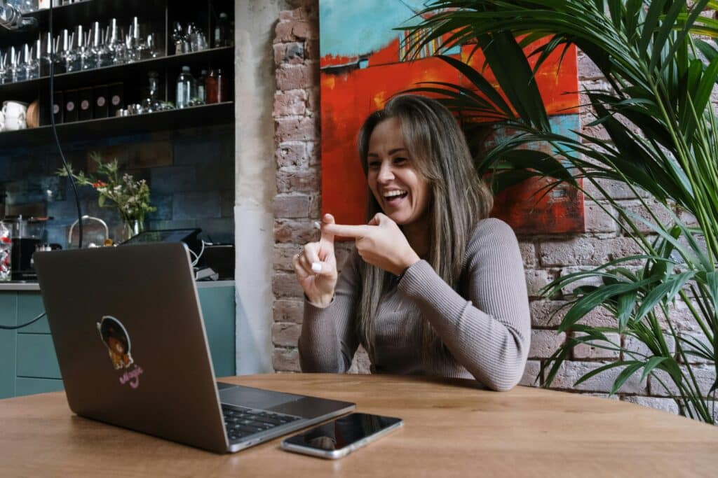 Woman in cafe using sign language on computer.